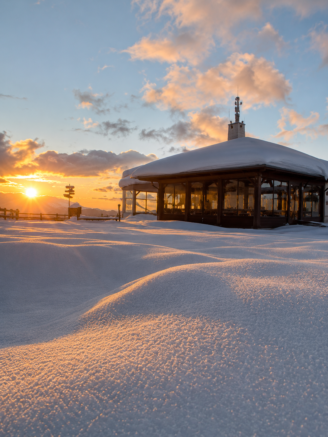 Häuschen auf dem Berg im Schnee bei Sonnenuntergang (KI-generiert)